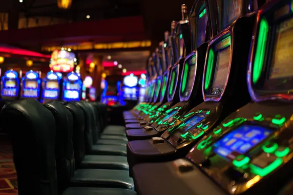 Một cô gái trong bộ váy xanh sang trọng đứng cạnh vòng roulette, gợi lên bầu không khí casino cao cấp của F8BER.
